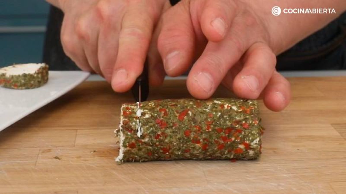 Corta el rulo de queso de cabra con finas hierbas