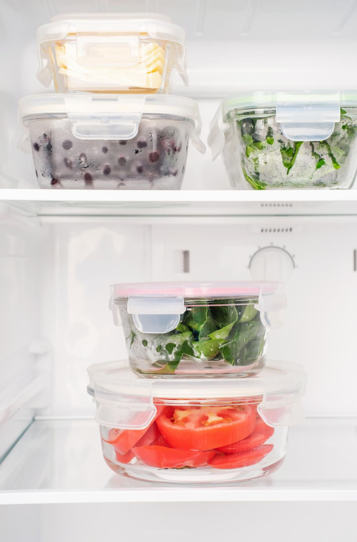 Nevera con alimentos saludables dentro de envases de vidrio.