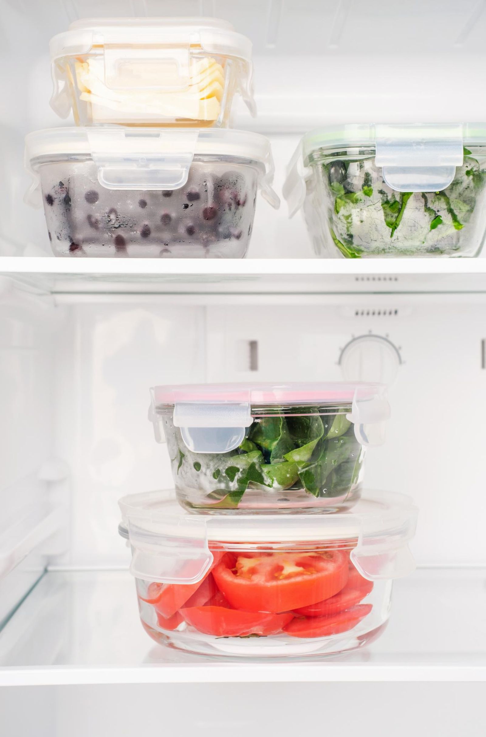 Nevera con alimentos saludables dentro de envases de vidrio.
