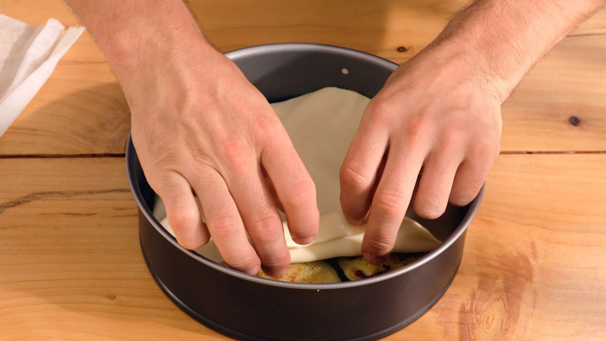 El hojaldre añade una textura crujiente que complementa los sabores de la berenjena y los piñones