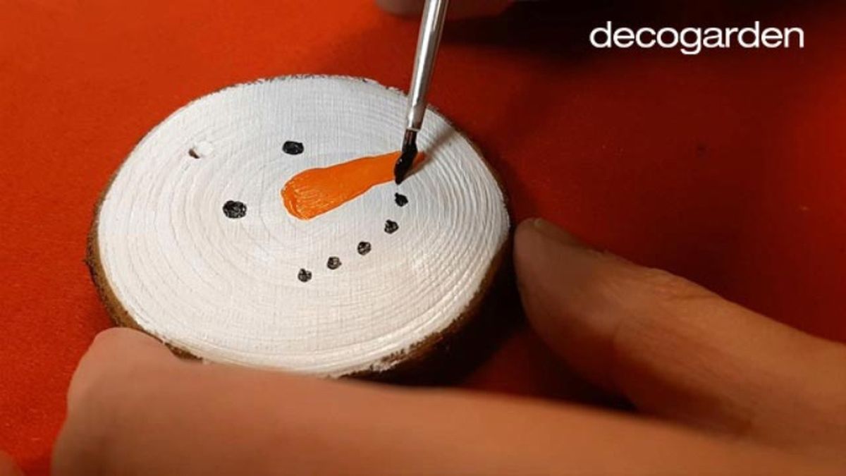 Pintar un muñeco de nieve navideño en un disco de madera.