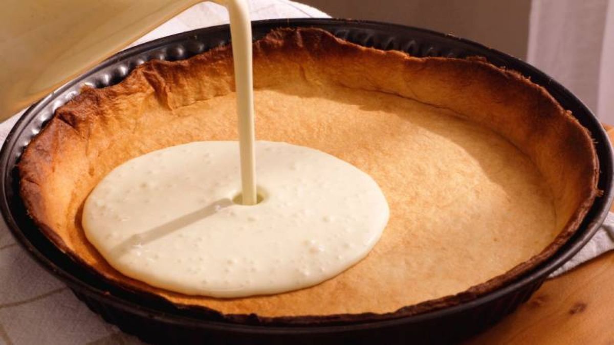 Vierte la nata sobre la base de galleta para crear la cremosidad perfecta en tu tarta de queso