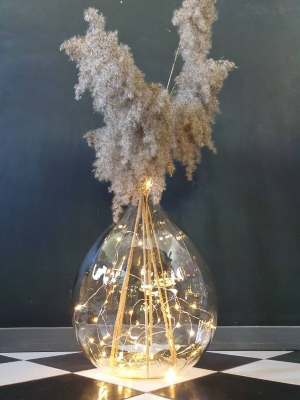 Damajuana decorada con pampa decorativa y luces.