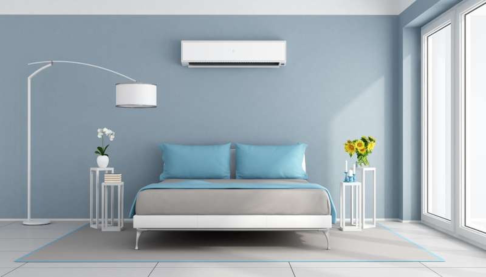 Dormitorio azul decorado con una orquídea blanca y girasoles.