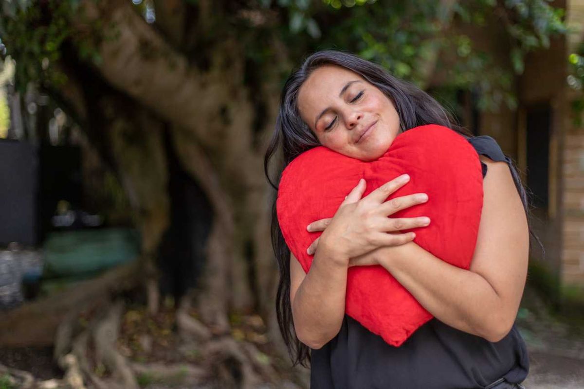 Mujer abrazando un cojín de San Valentín.