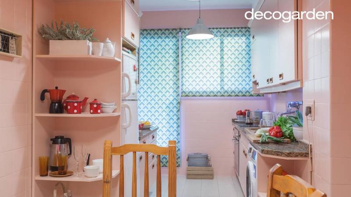 Cocina rosa con estantería esquinera para aprovechamiento vertical.