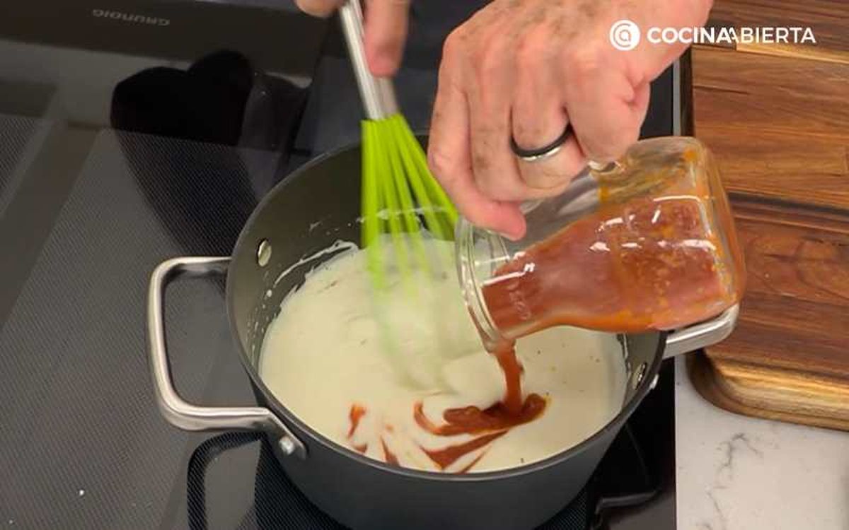 Vierte la salsa de tomate sobre la bechamel y mezcla
