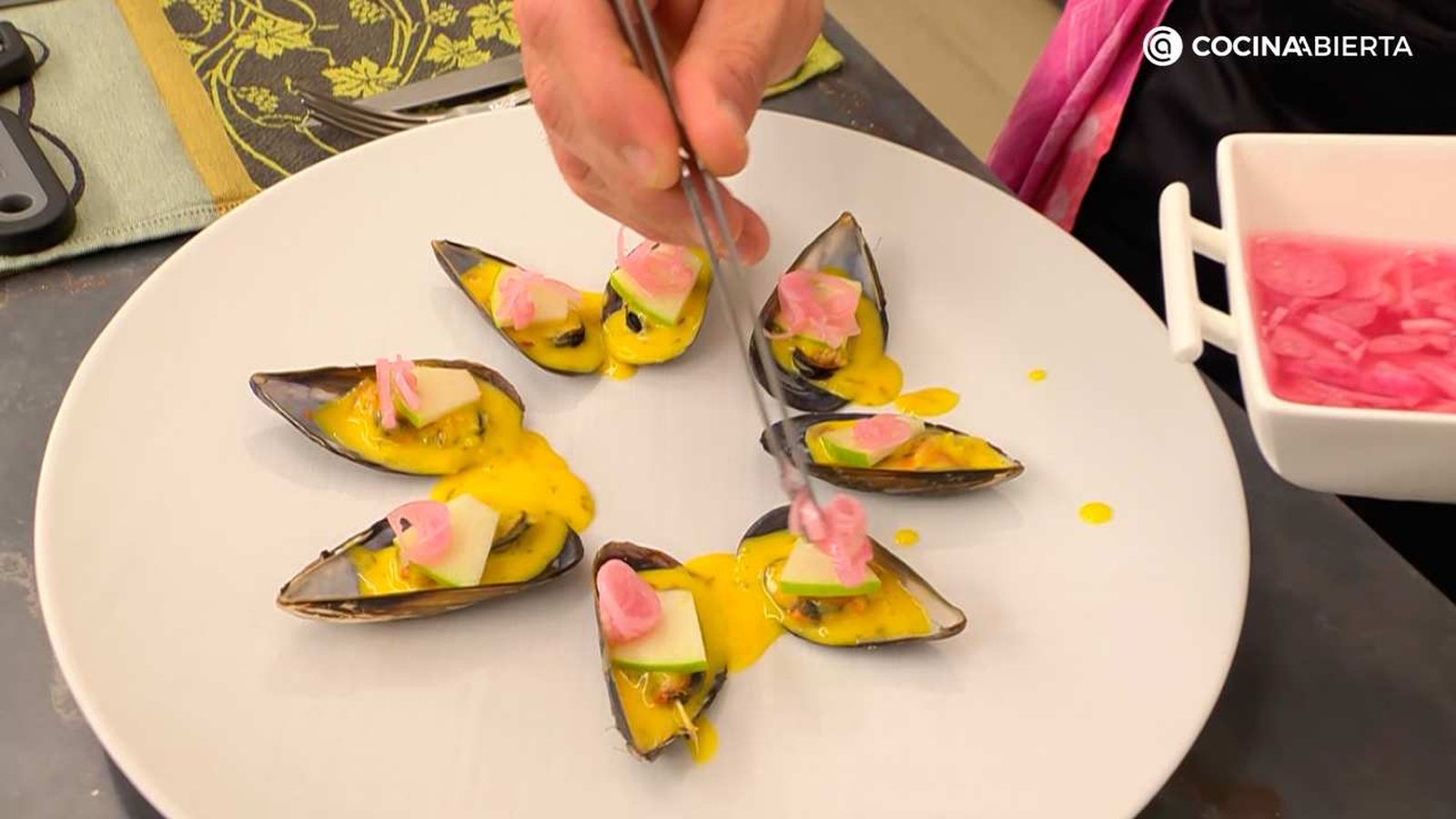 Pon una lámina de manzana y unos pickles encima de los mejillones