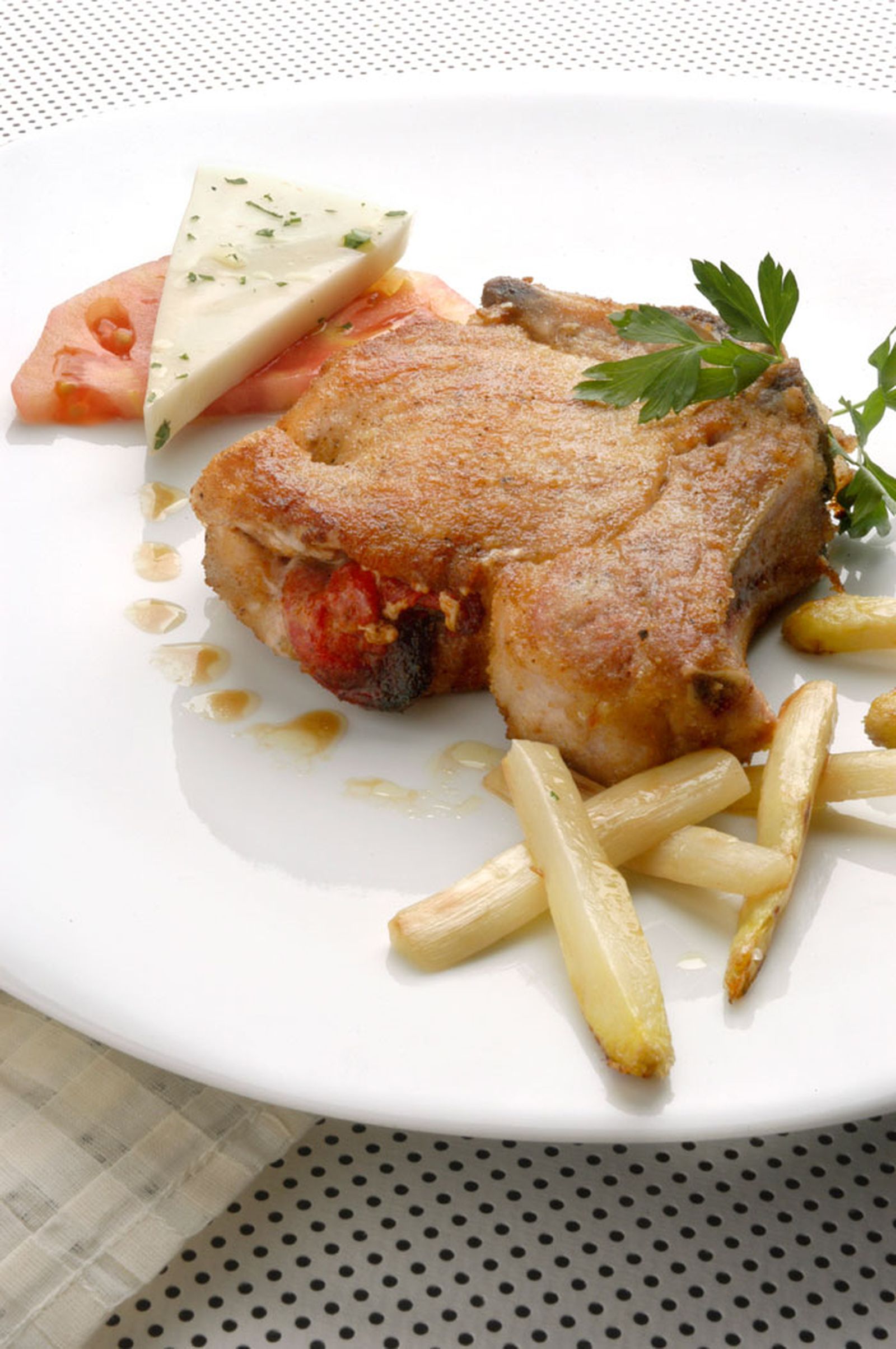 Chuleta de cerdo con ensalada de tomate y queso