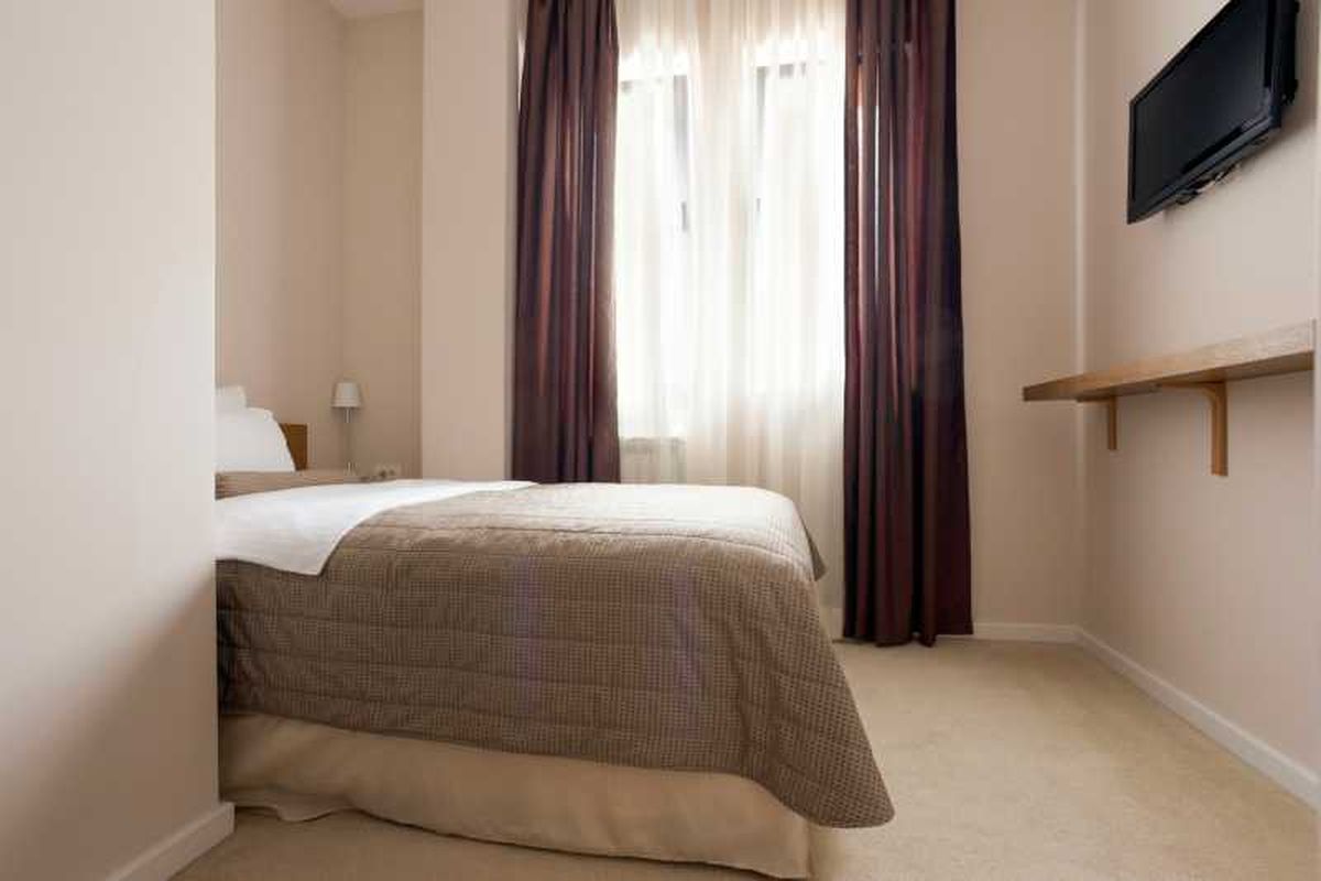 Dormitorio pequeño con balda en la pared.