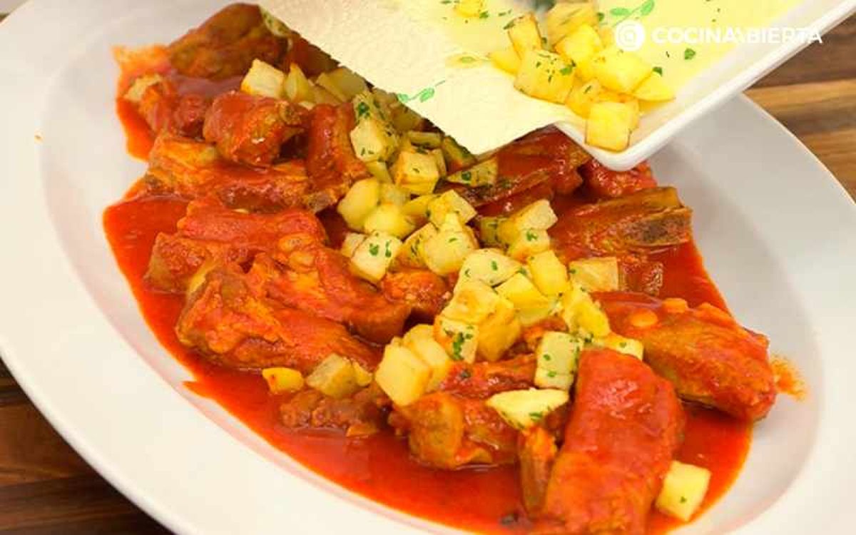 Sirve las costillas de cerdo en salsa roja con patatas