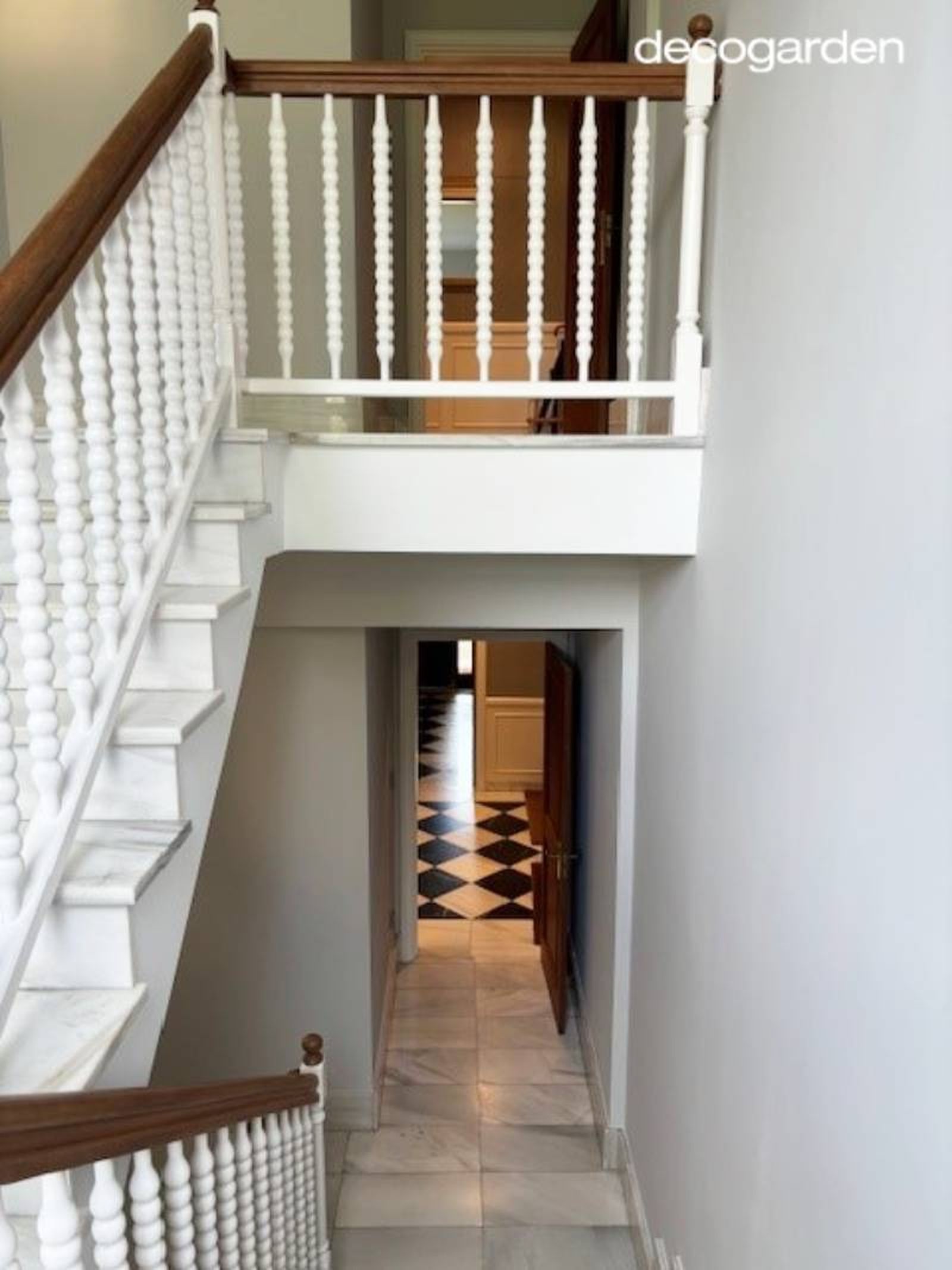 Escaleras y barandilla renovadas en blanco y madera natural.