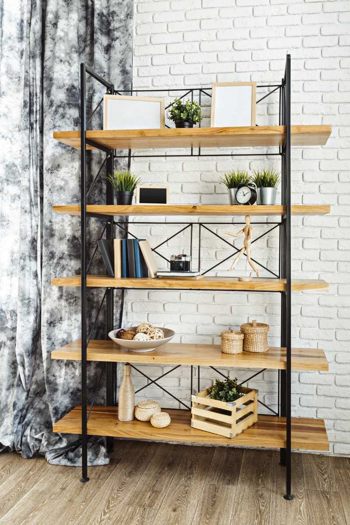 Estantería industrial de madera y metal con adornos.