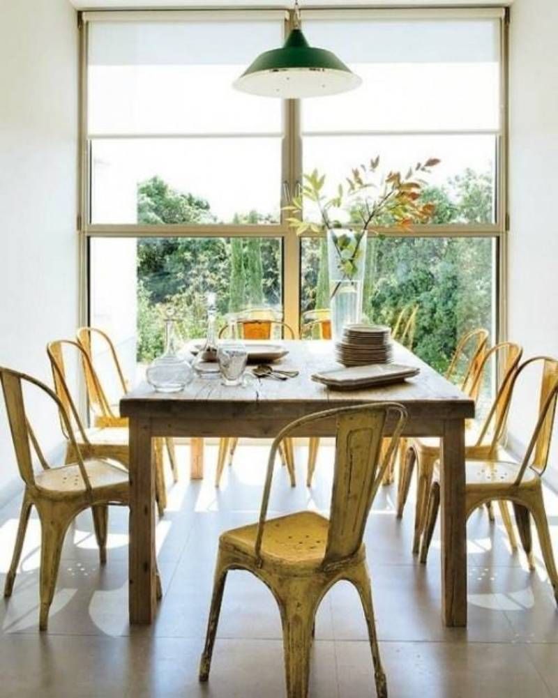 Comedor de estilo industrial con sillas de metal amarillas de efecto desgastado.