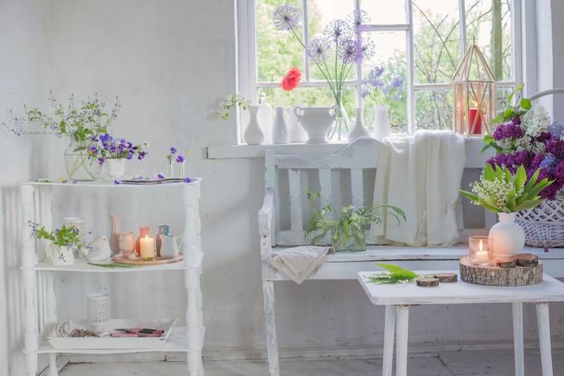 Rincón acogedor en la ventana decorado con cerámica y plantas.