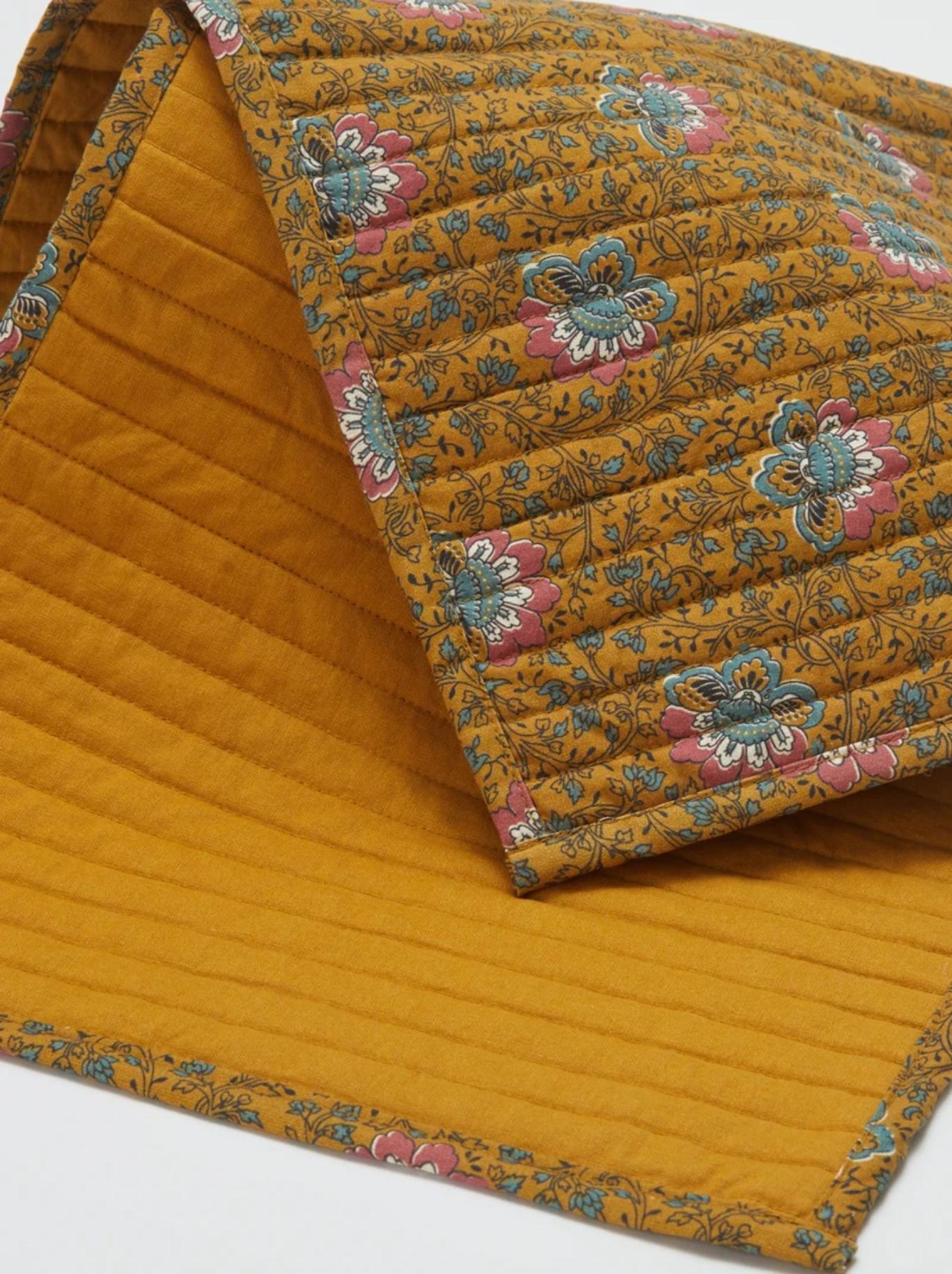 Mantel individual reversible amarillo de flores.