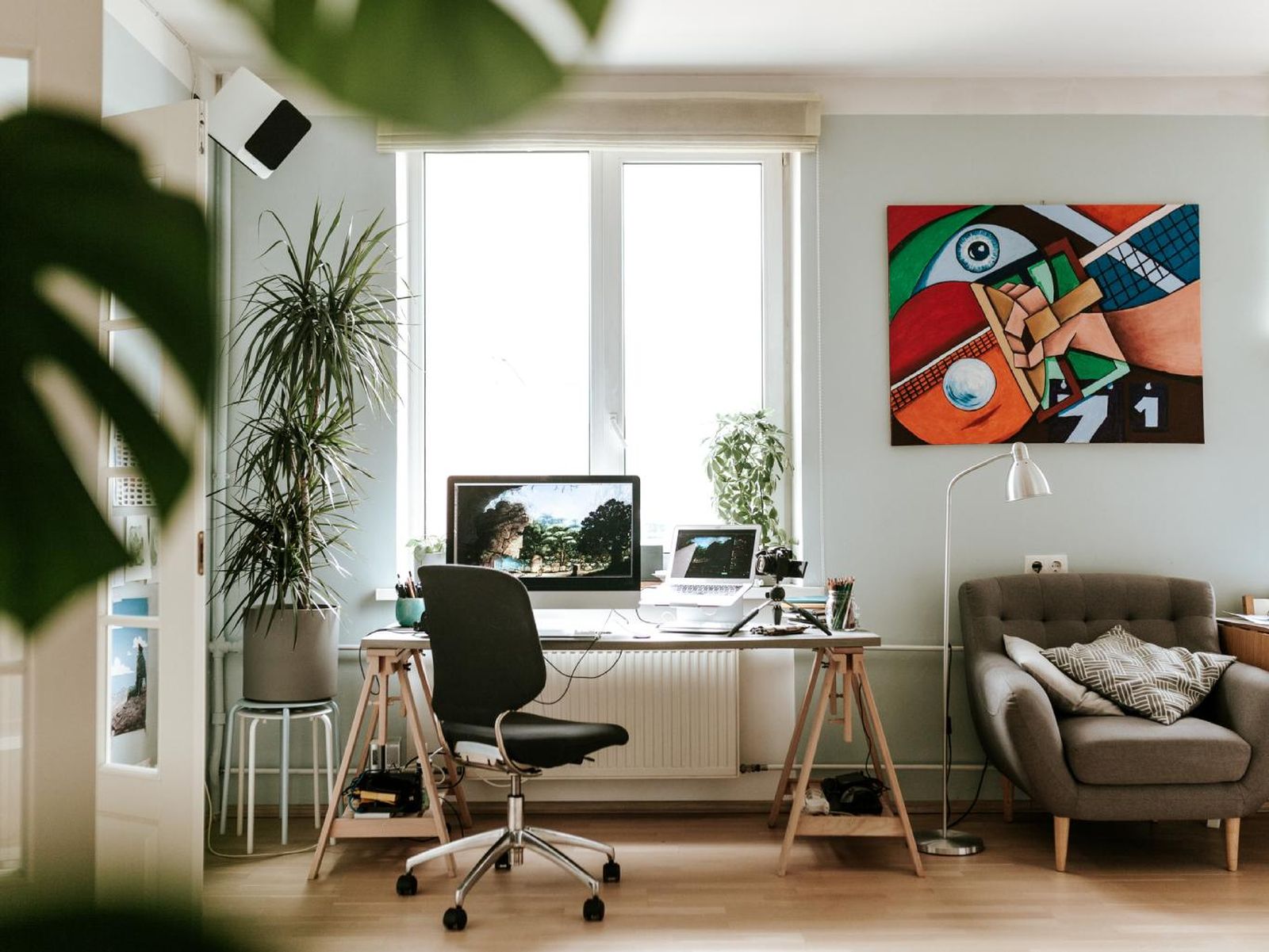 Oficina en casa decorada con plantas y arte.