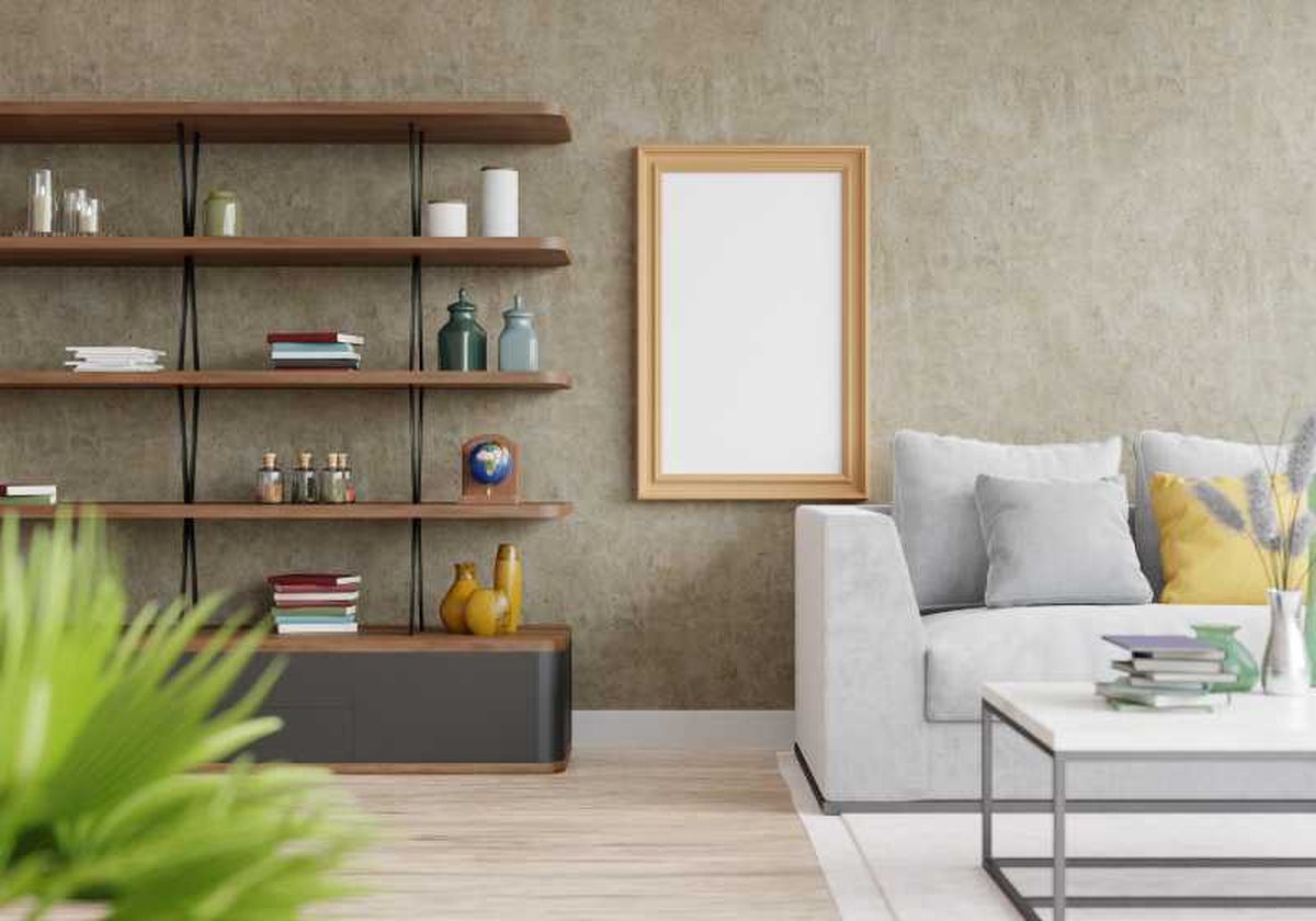 Salón agradable con sofá gris, estantería y pared marrón con textura.