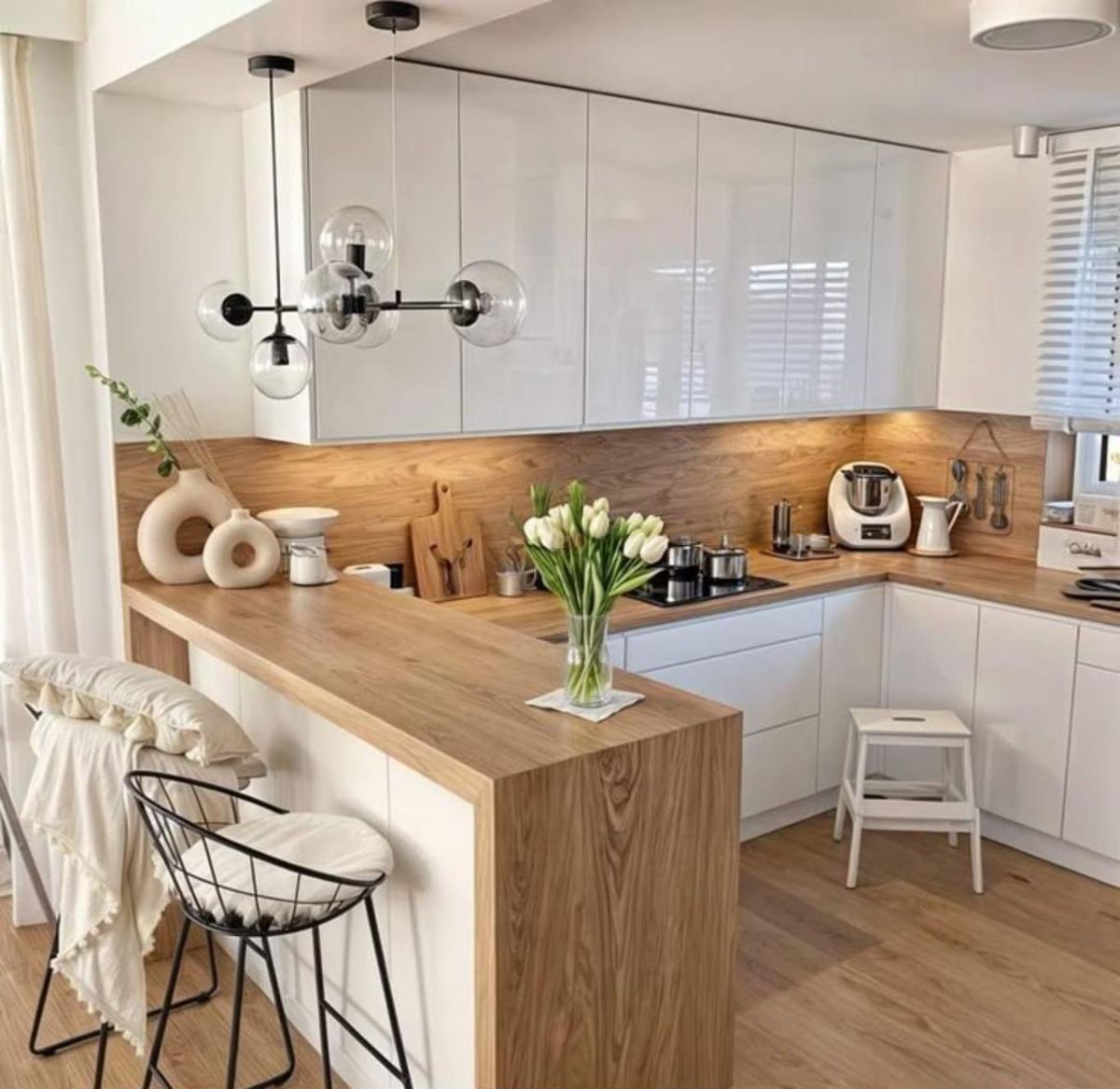 Cocina con península decorada con complementos de materiales naturales.