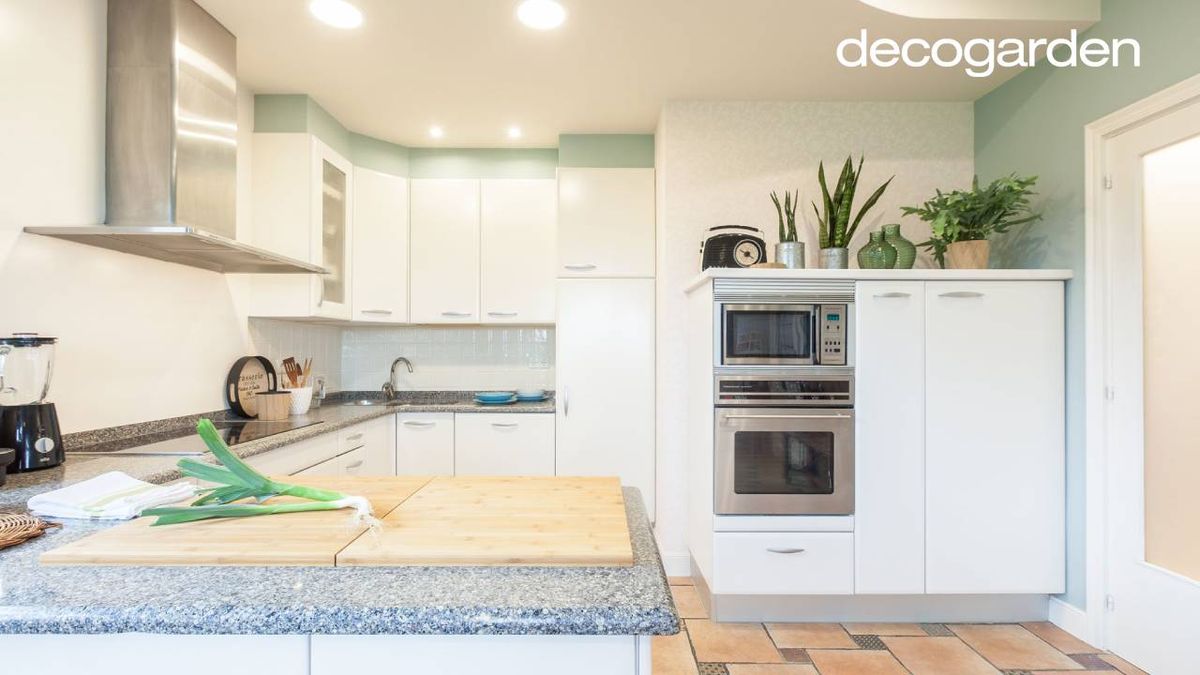 Cocina con los armarios pintados de blanco.