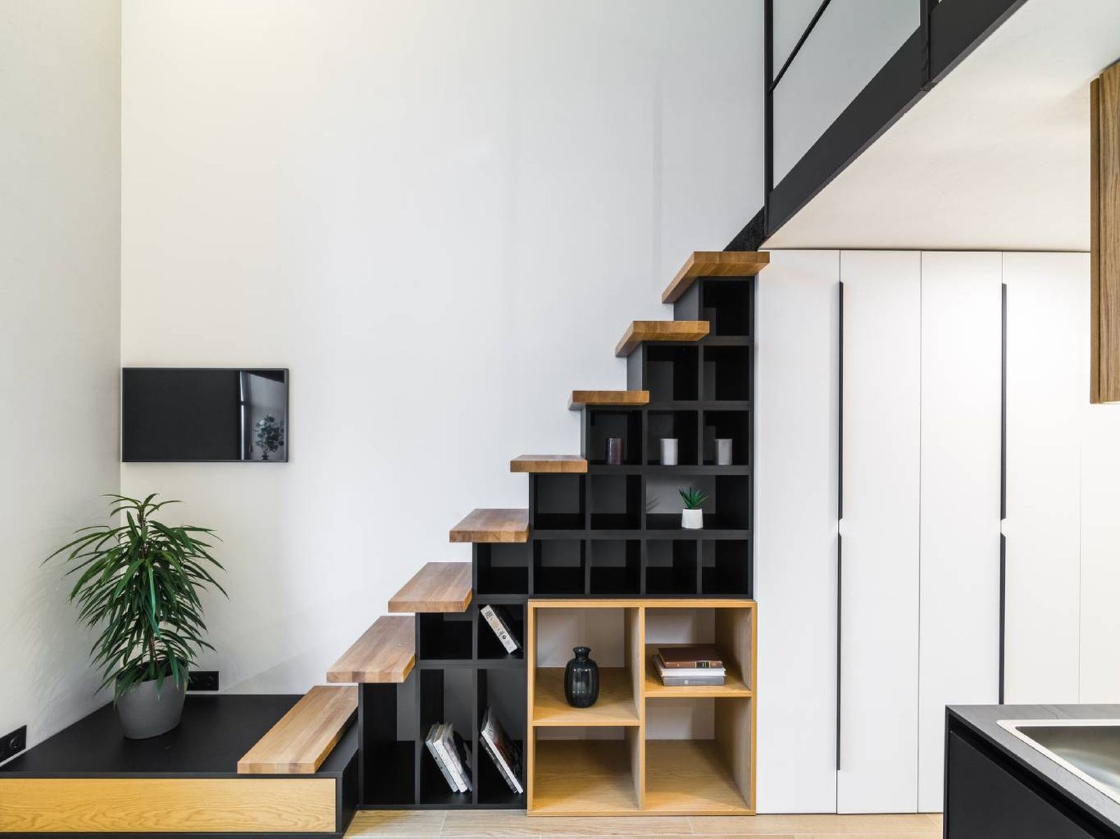 Una estantería abierta con módulos decorativos transforma este hueco en un punto focal de diseño.