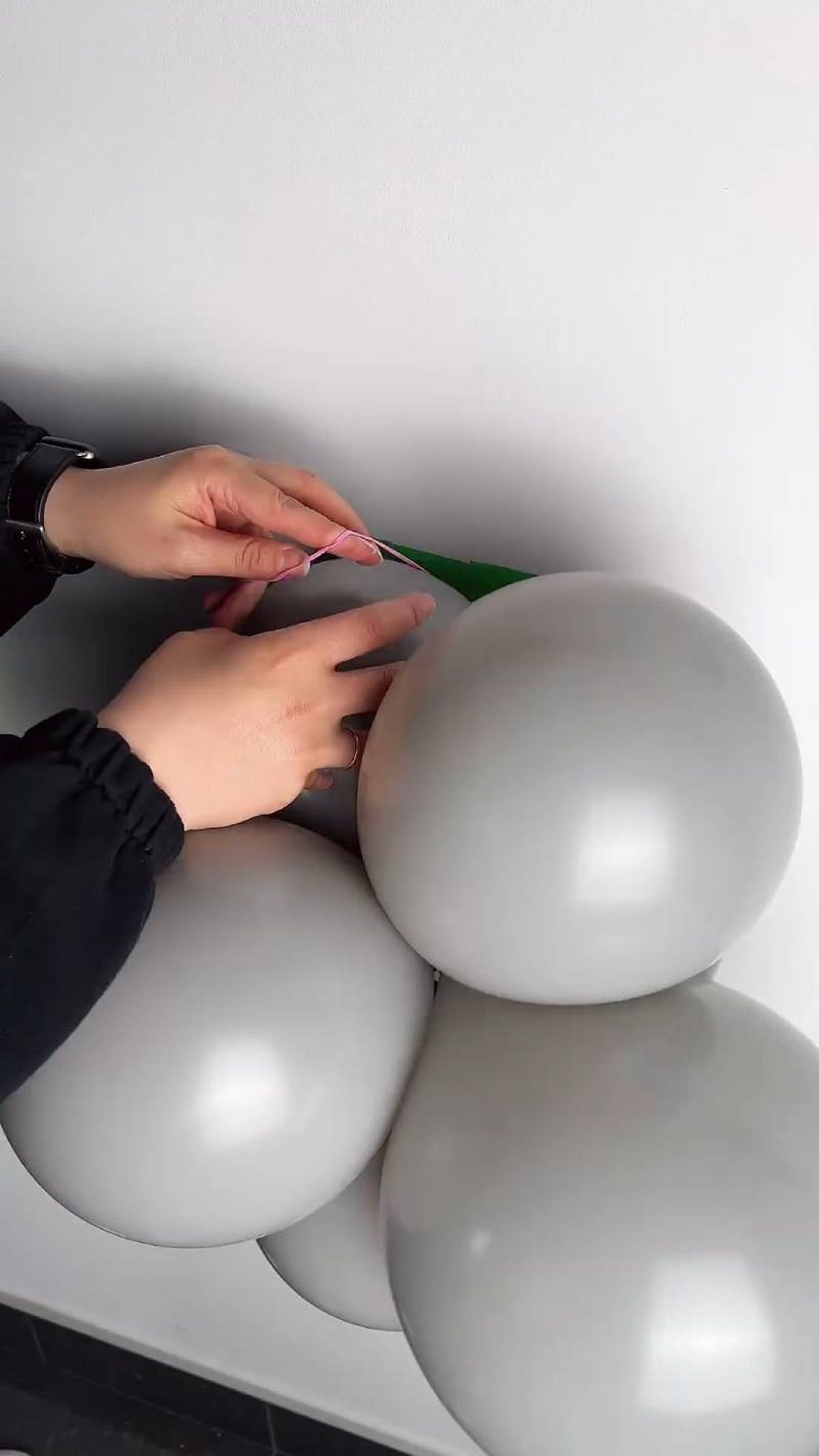 Meter los globos por la goma pegada en la pared.