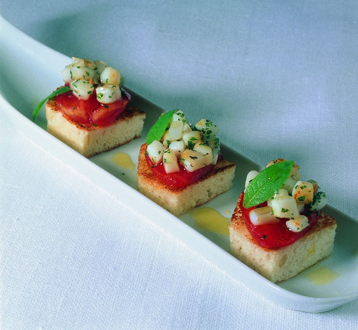 Pincho de chipirón y tomate seco con cebolleta tierna sobre tosta aliñada