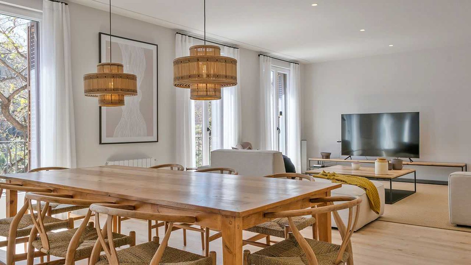 Comedor abierto al salón con muebles modernos.