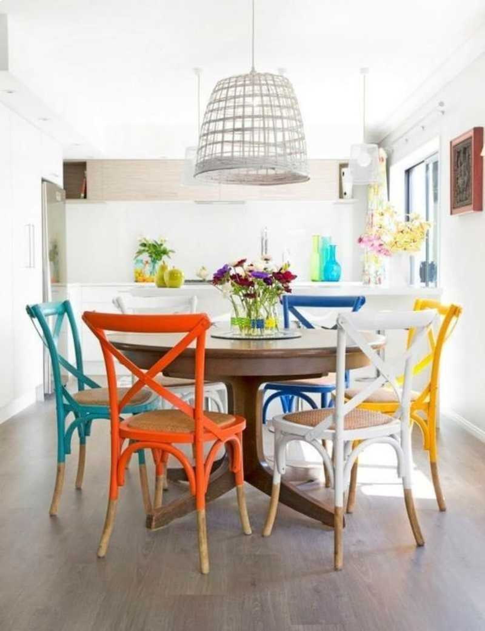 Cocina con sillas de colores pintadas con pintura a la tiza.