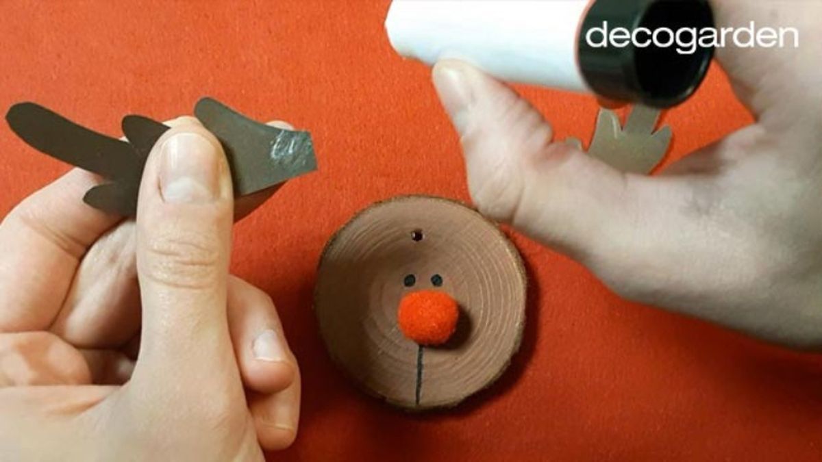 Pegar las astas al disco de madera pintado de reno.