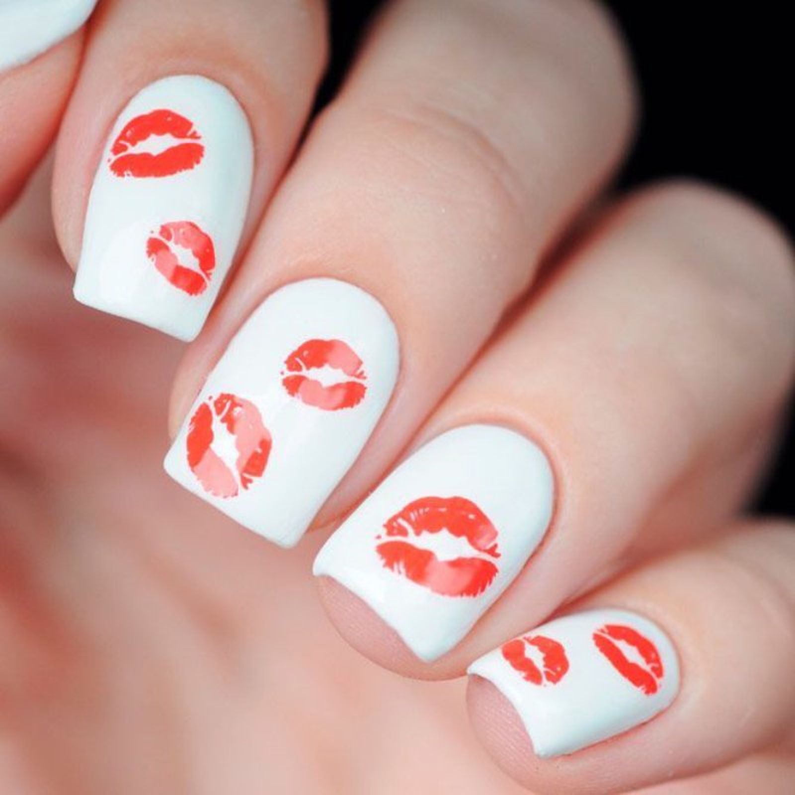 Manicura en blanco con dibujos de labios rojos