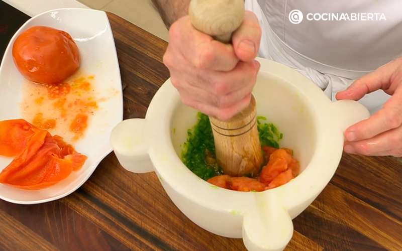 Maja los pimientos y ajos con el tomate