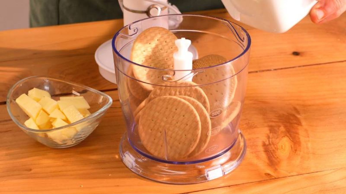 Tritura las galletas y mezcla con mantequilla para crear la base perfecta de la tarta de queso