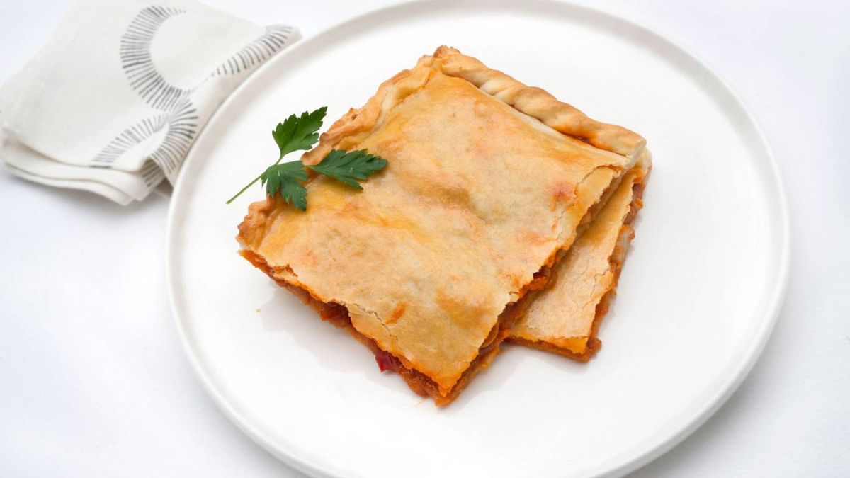 Empanada gallega de zamburiñas, crujiente y rellena de sofrito tradicional.