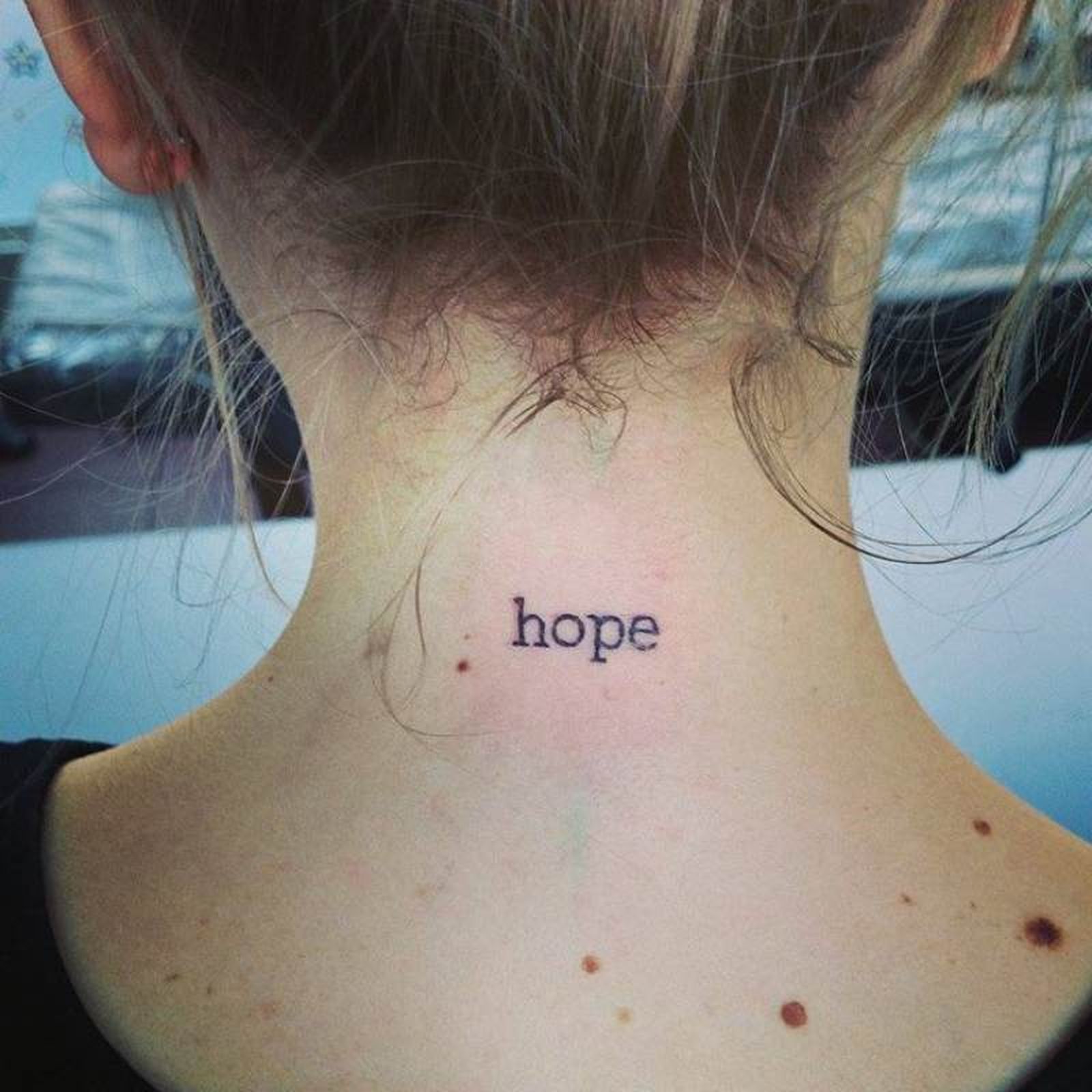 Pequeño tatuaje en al nuca