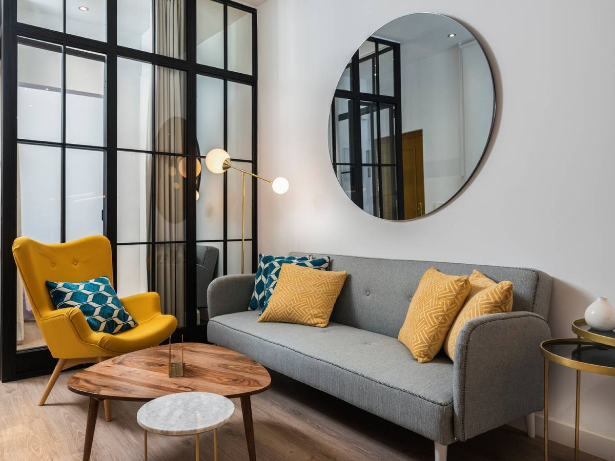 El gris y el amarillo crean contraste en este salón de inspiración industrial con toques retro.