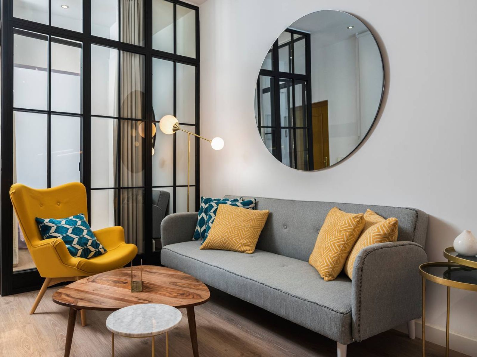 El gris y el amarillo crean contraste en este salón de inspiración industrial con toques retro.