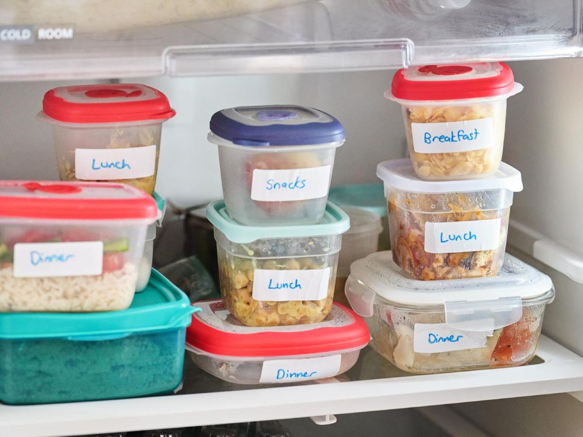 Tuppers transparentes con etiquetas dentro de la nevera.