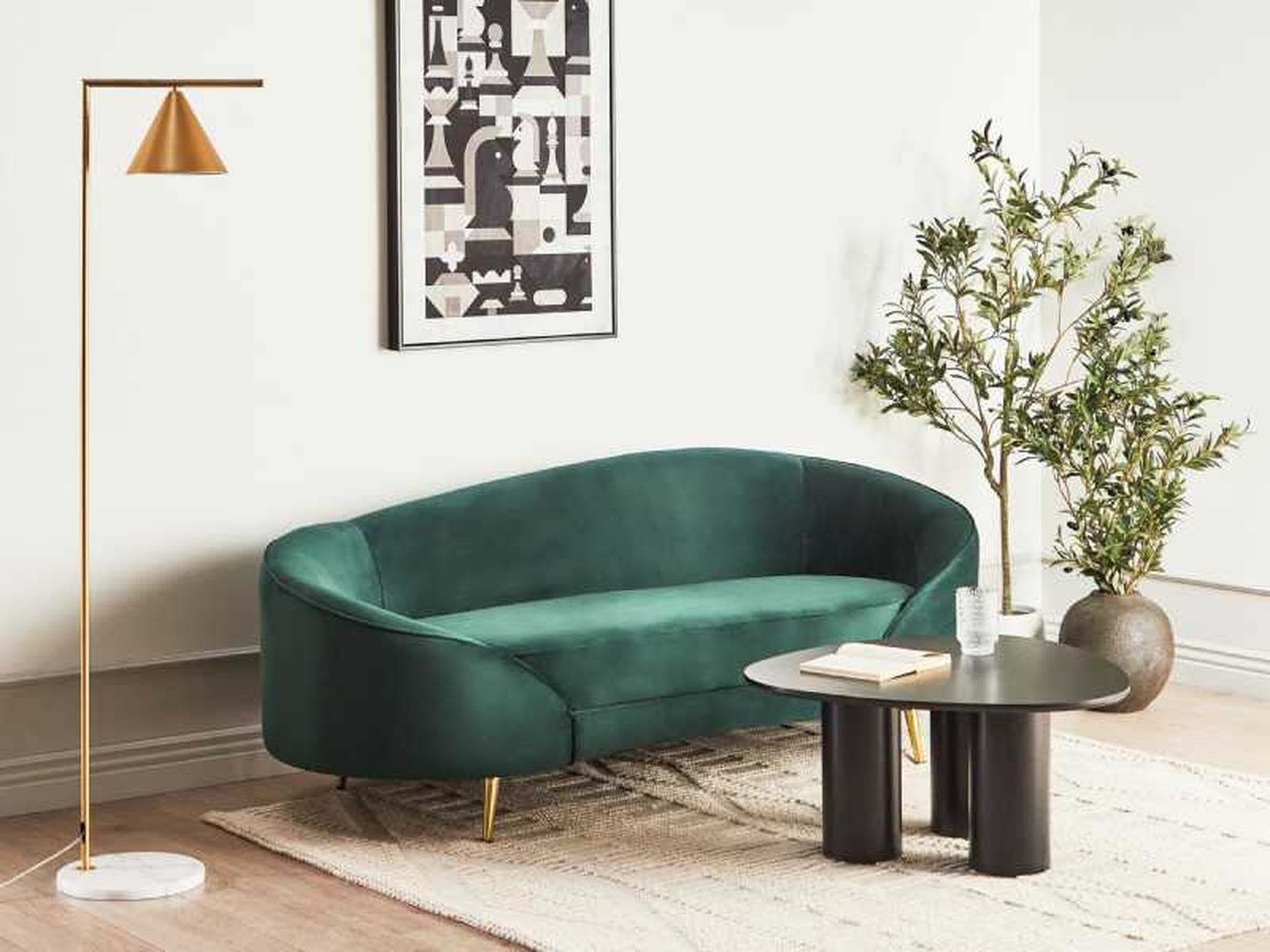 Salón con sofá verde curvo de terciopelo.
