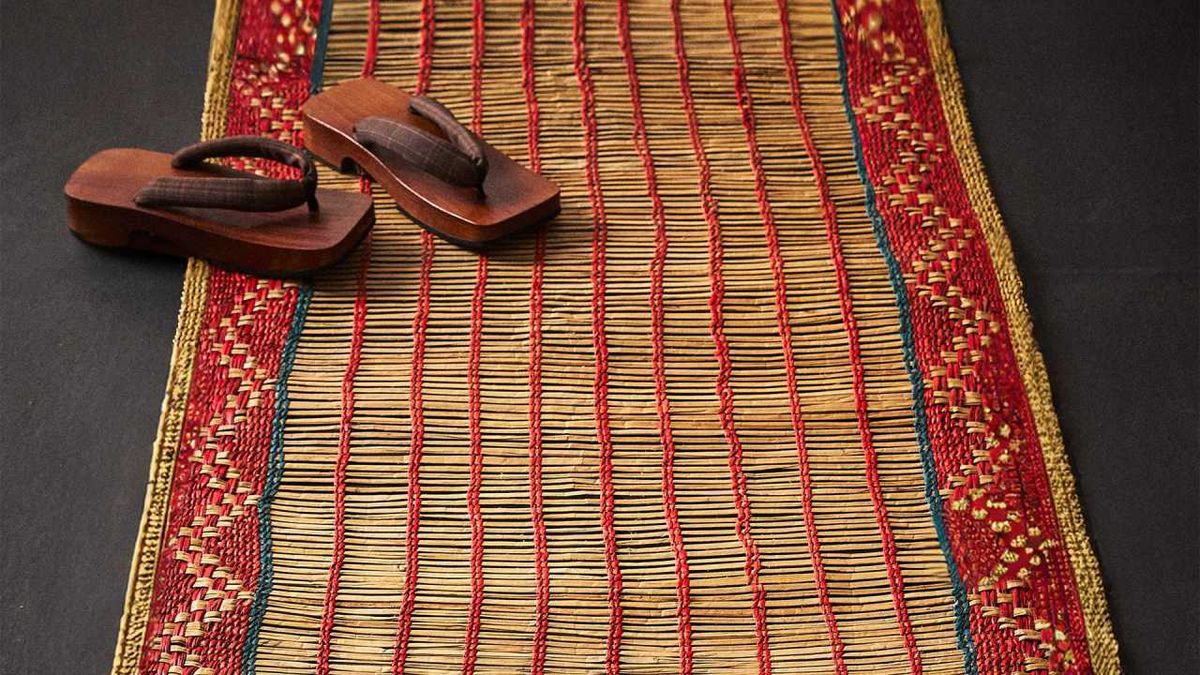 Alfombra pasillera de paja trenzada de estilo japonés y sandalias de madera tipo geta.