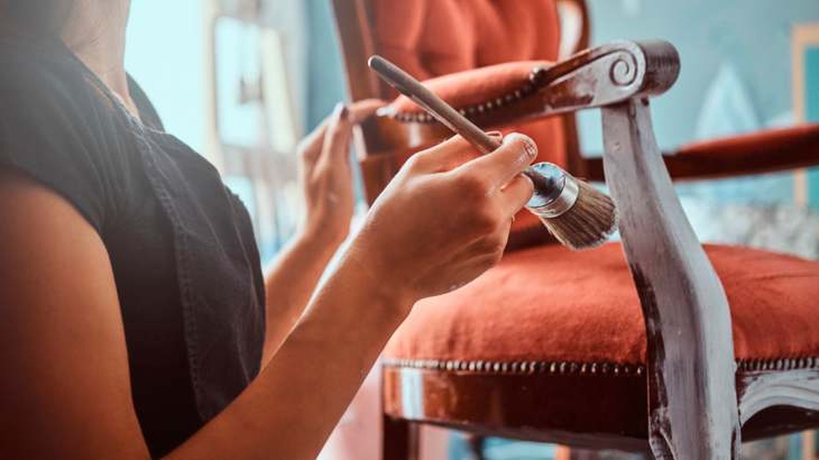 Persona pintando una silla de madera