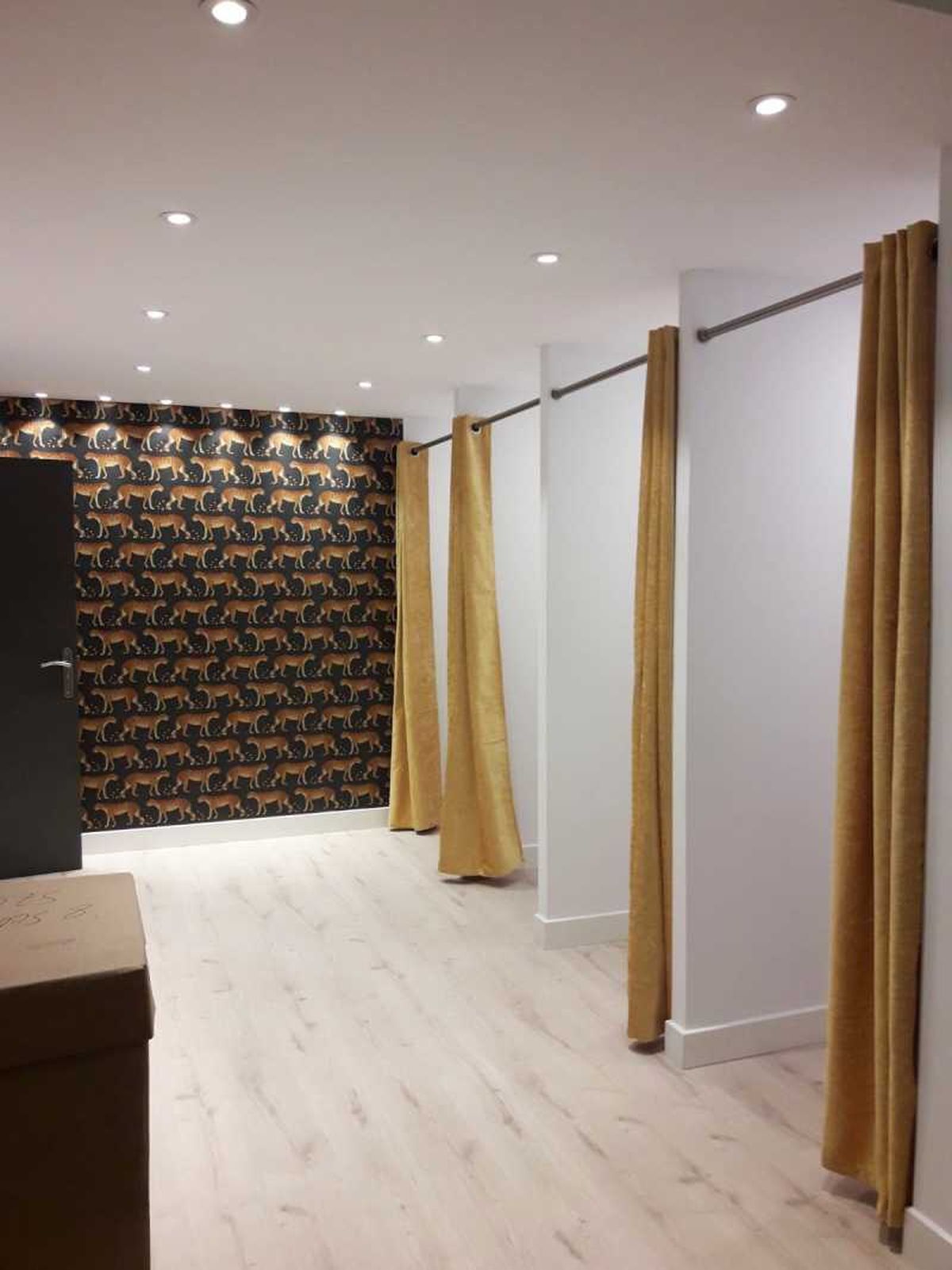 Zona de probadores con cortinas doradas.