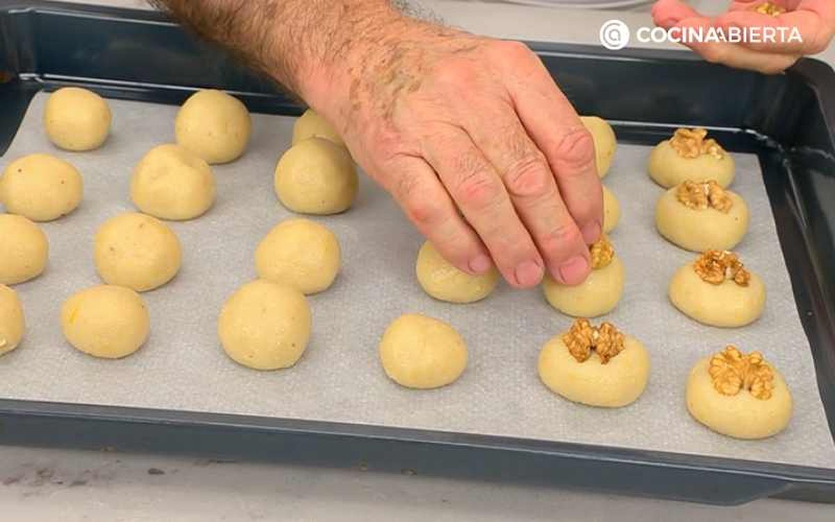 Coloca media nuez sobre cada bolita