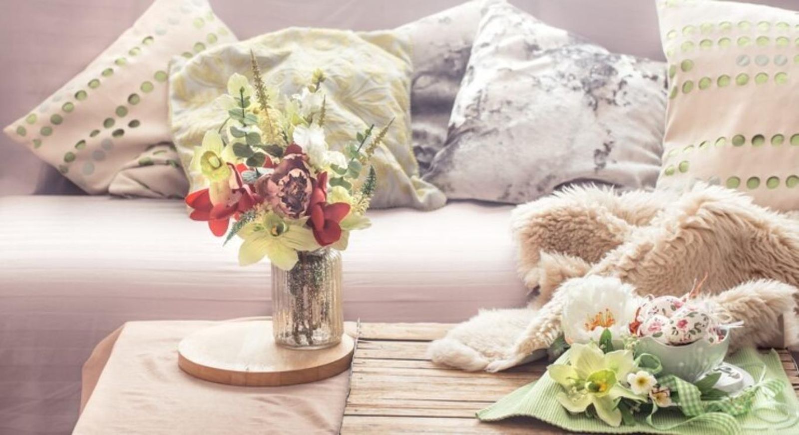 Mesa de comedor con jarrón con flores y textiles ligeros.