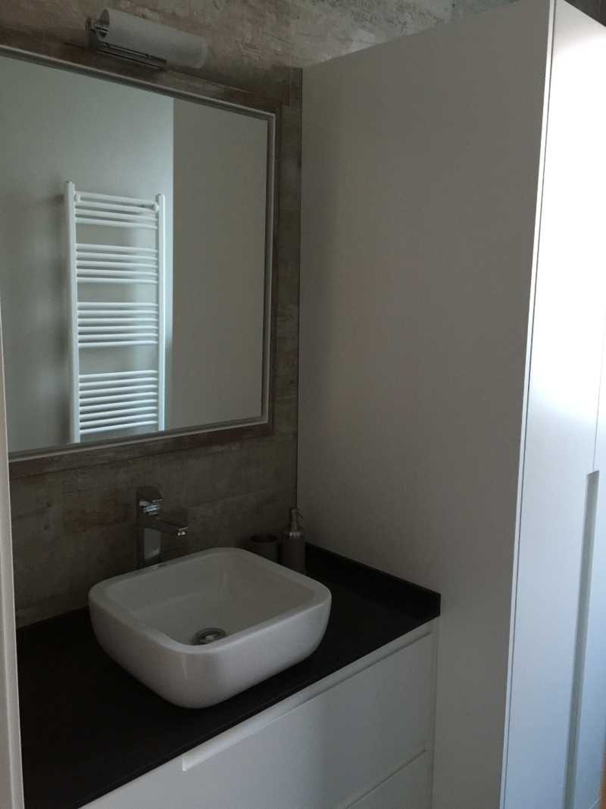 Baño pequeño con mueble para la lavadora y secadora.