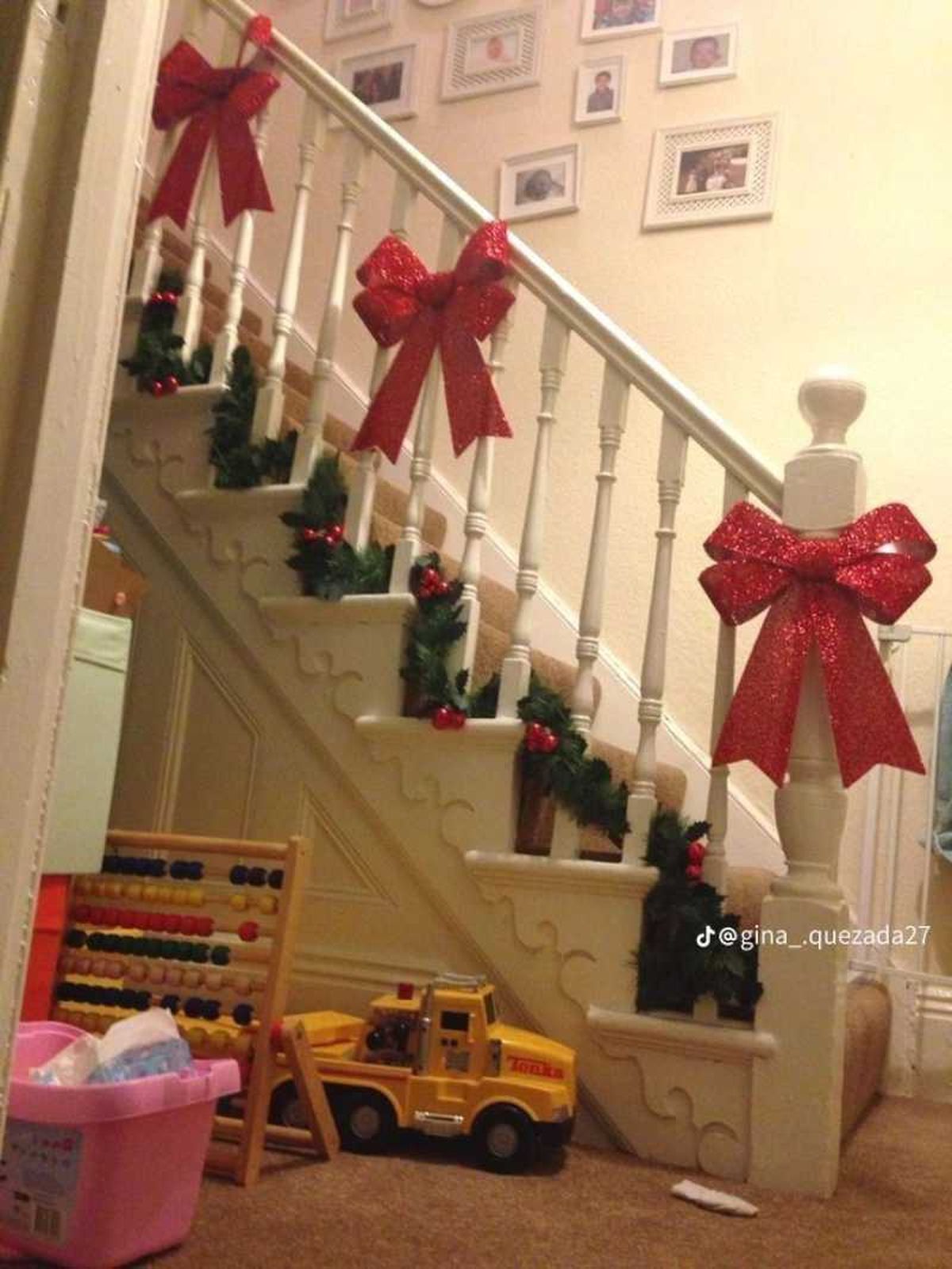 Escalera interior decorada con lazos rojos navideños.