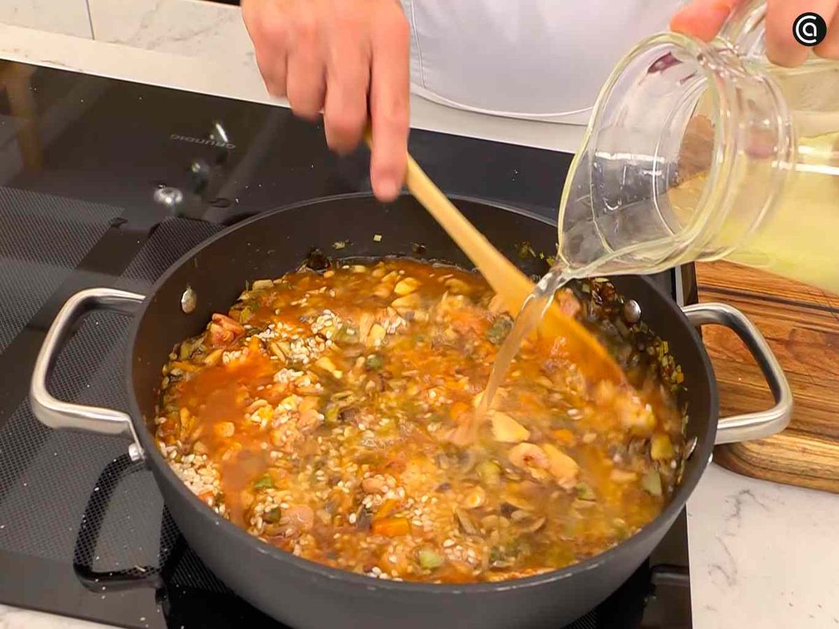 Añade el caldo, el pollo y el arroz