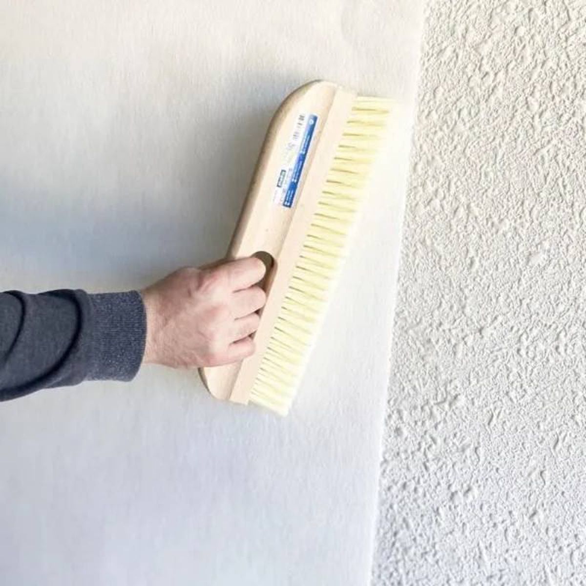 Colocación de papel cubre gotelé sobre la pared.