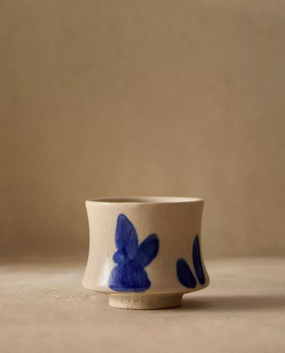 Mini taza de cerámica con motivos pintados.
