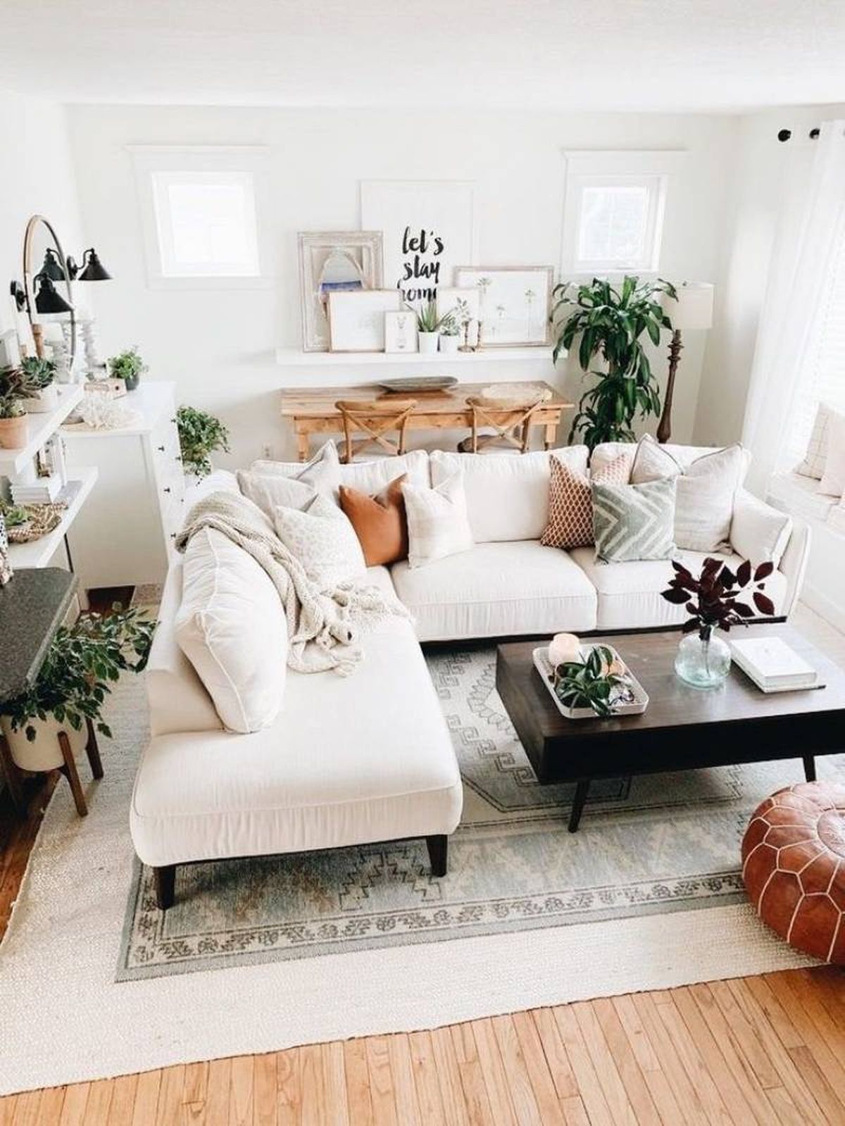 Salón hygge decorado en blanco con plantas.